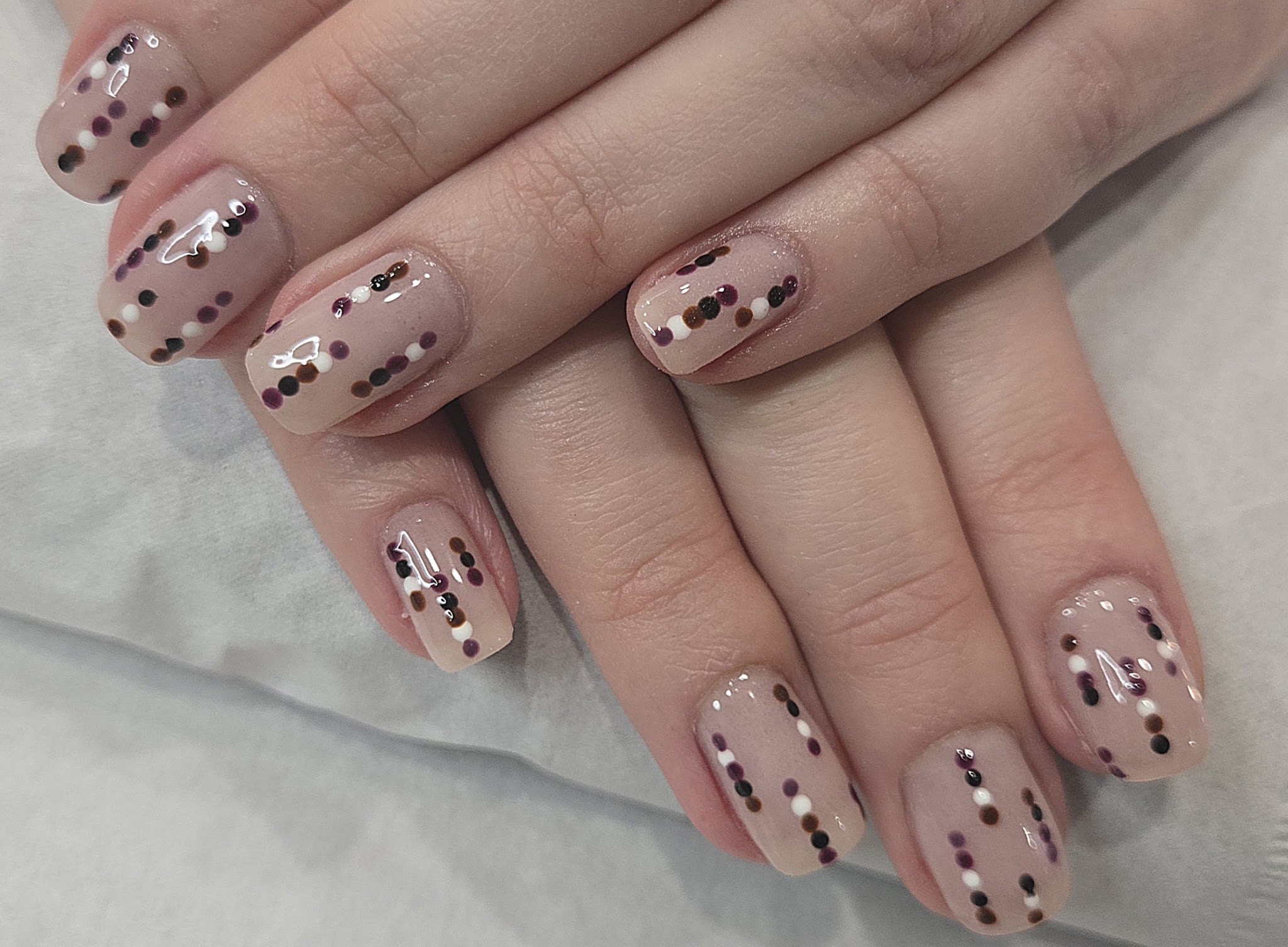 Nude nails with black and gold dots
