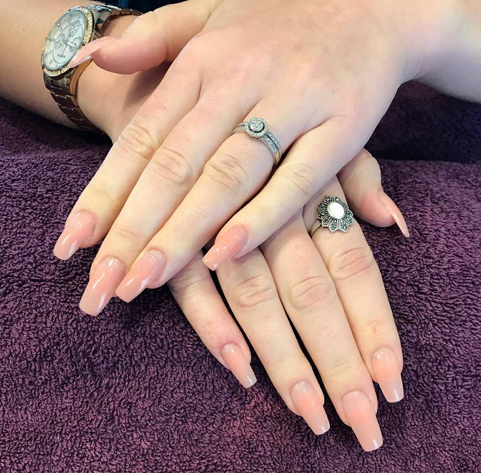 Long natural-pink nail extensions